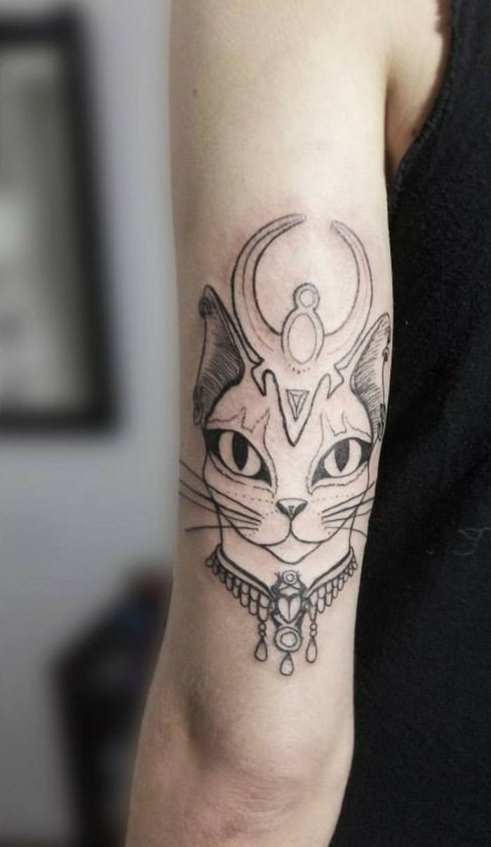 Ideea pentru un tatuaj de pisică - aici este o mână cu o pisică egipteană cu ochi mari și un colier și bărbii de buze superioare