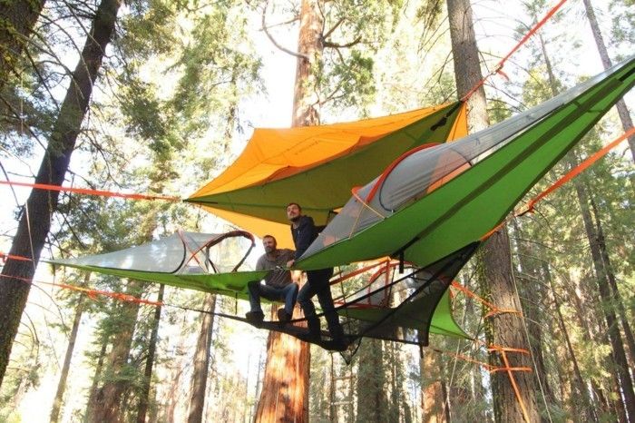 stay-in-skogen-a-gul-och-en-grön-camping tält på marken