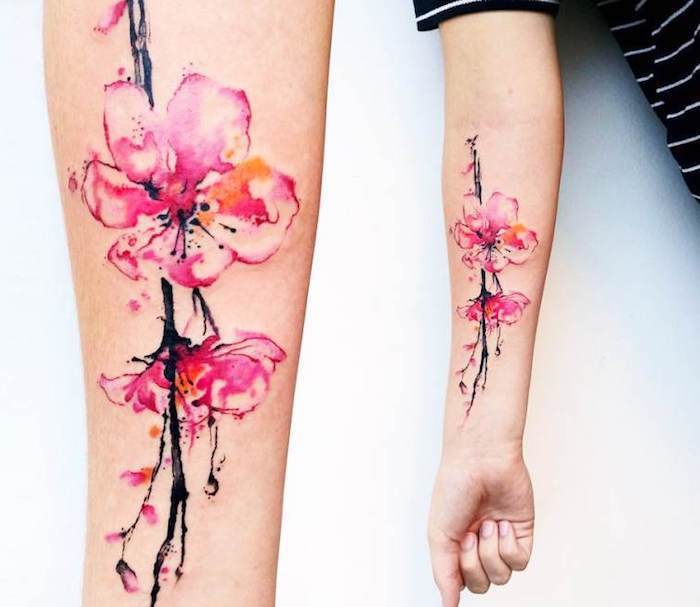 tattoo betekenis, aquarel tattoo met kersenbloesem motief op de onderarm