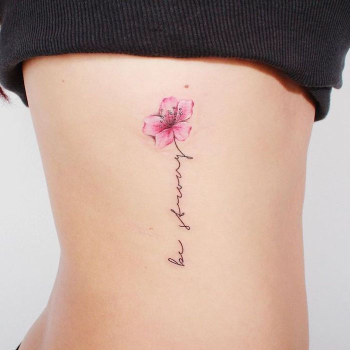 tattoo belettering, vrouw mi klener tattoo mi bloemen motief aan de lichaamszijde