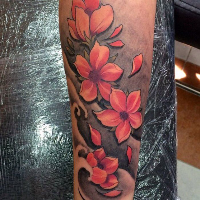 kersenbloesemtatoeage op de onderarm, tatoeage met watergolven en rode bloemen