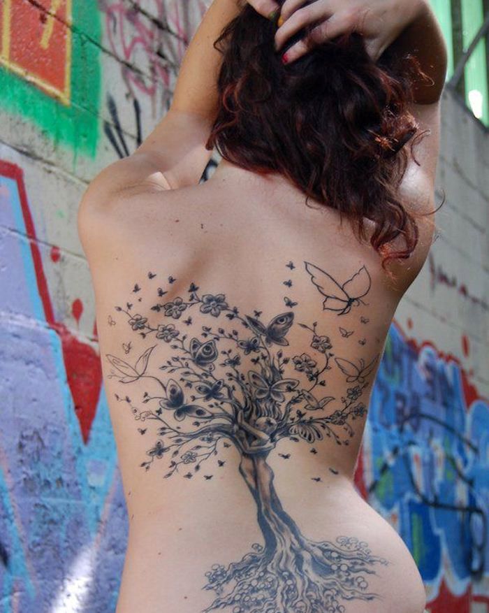 Tattoo betekenis, vrouw met grote tattoo in zwart en grijs, kersenboom