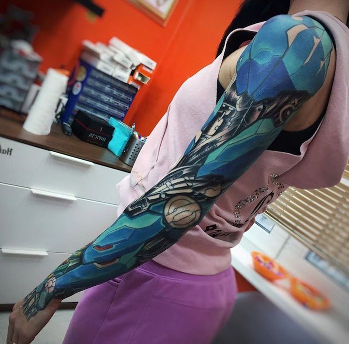 Femeie cu tatuaj de brat superior în construcție și tatuaj biomecanic negru