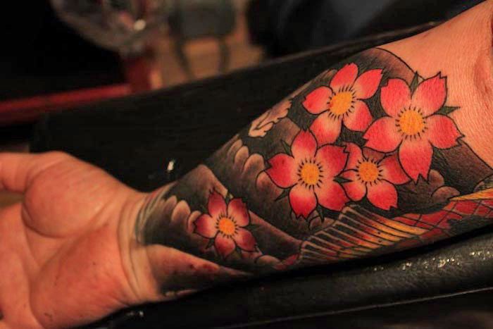Japanse tatoeages, koitvissen in combinatie met watergolven en roze kersenbloesems