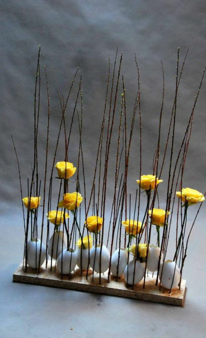 Velikonočno dekoracijo sestavljajo lesena jajca in cvetje