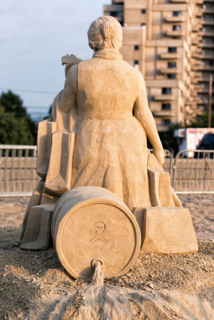 Sand sculpture-cum-sociale-messaggio-on-the-Кonsumgesellschaft