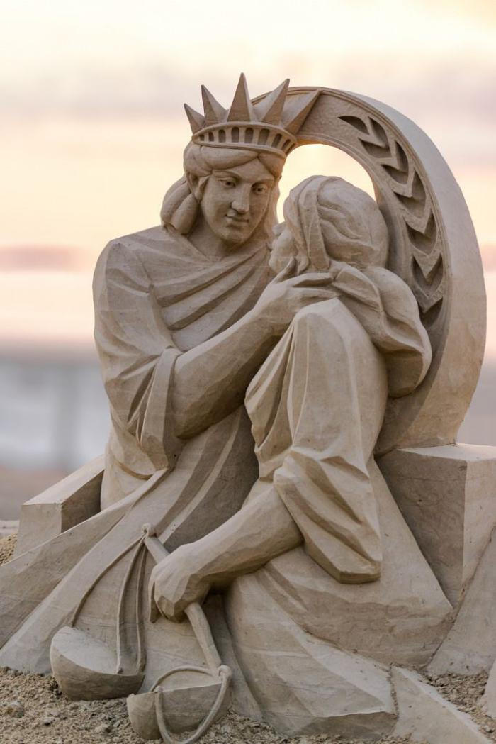 Sand sculpture of-the-statua-della-libertà-abbraccia-la Statua della giustizia