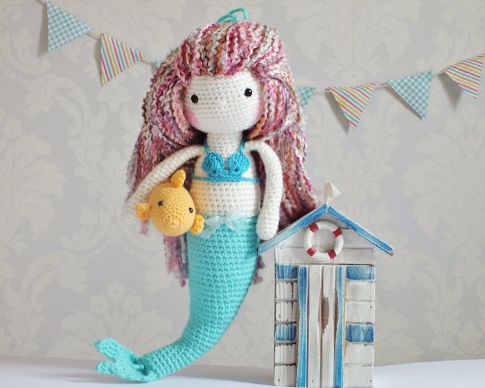 en blå havfrue med farget hår og gul fisk heklet lykke sjarm under armen