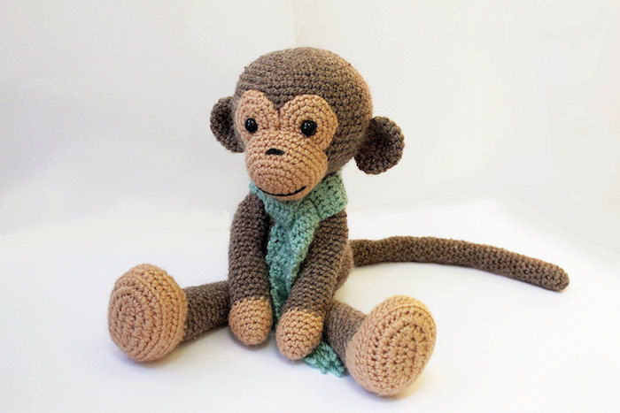 en søt ape i brun farge med et grønt skjerf - Amigurumi hekle mønster