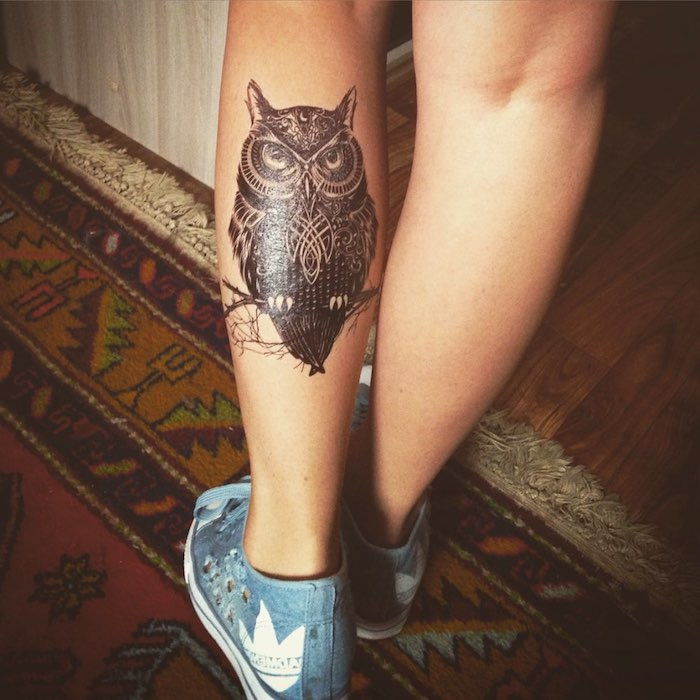 questa è una delle nostre idee sul tatuaggio del gufo: un piccolo gufo nero e un ramo su una gamba