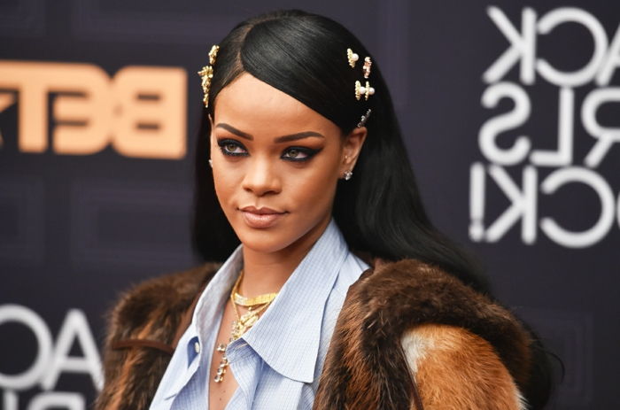 gyllene smycken på svart rakt hår, blå tröja - Rihanna frisyrer