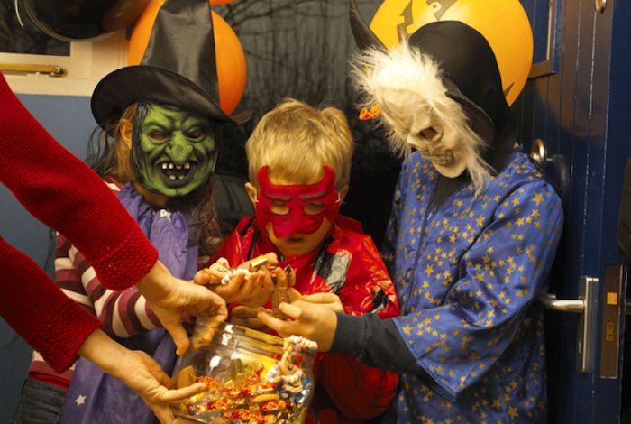 Halloween bilder - några barn med läskiga masker samlar godis