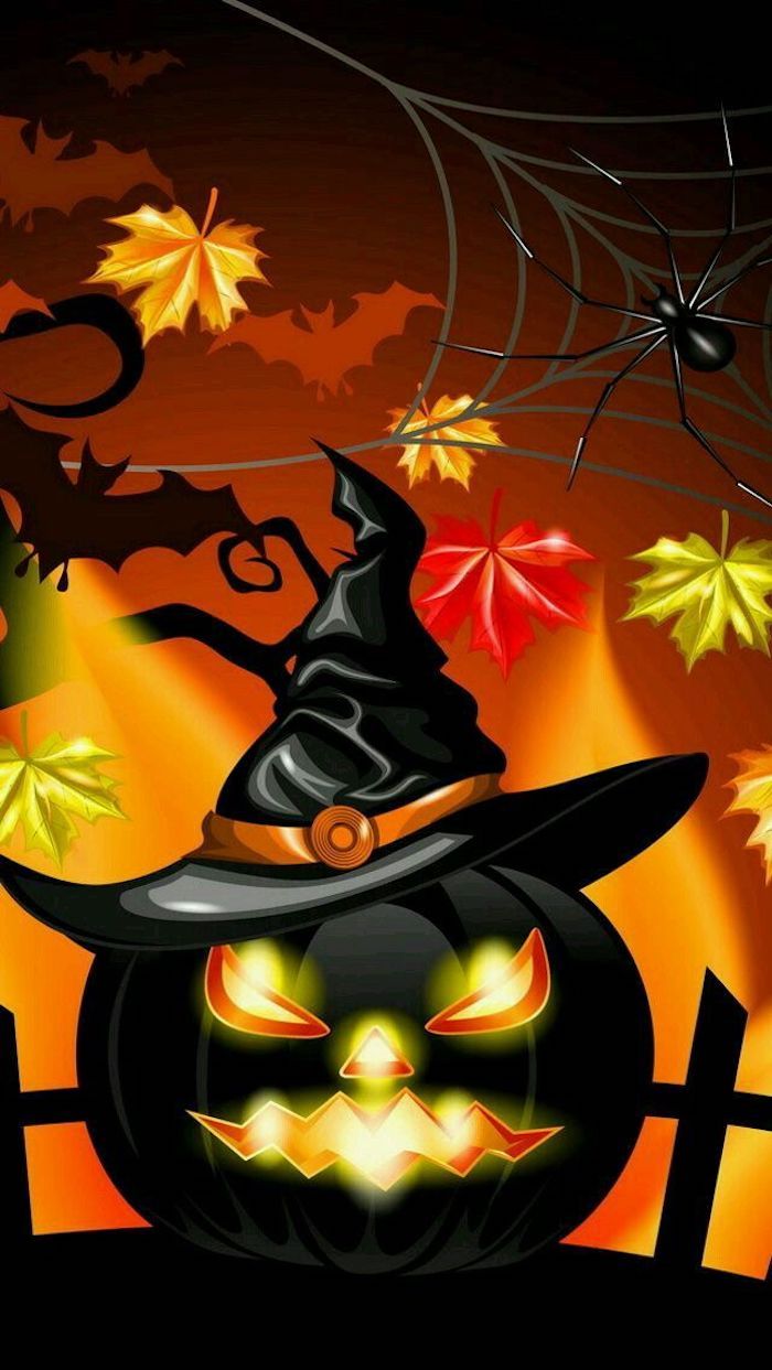 en svart halloween pumpa med häxhatt och lite färgstarka löv runt den
