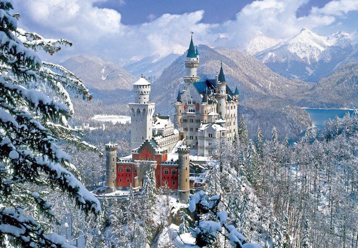 un castello bianco con torri - belle immagini invernali - cielo blu con nuvole bianche - foresta con alberi e neve e lago