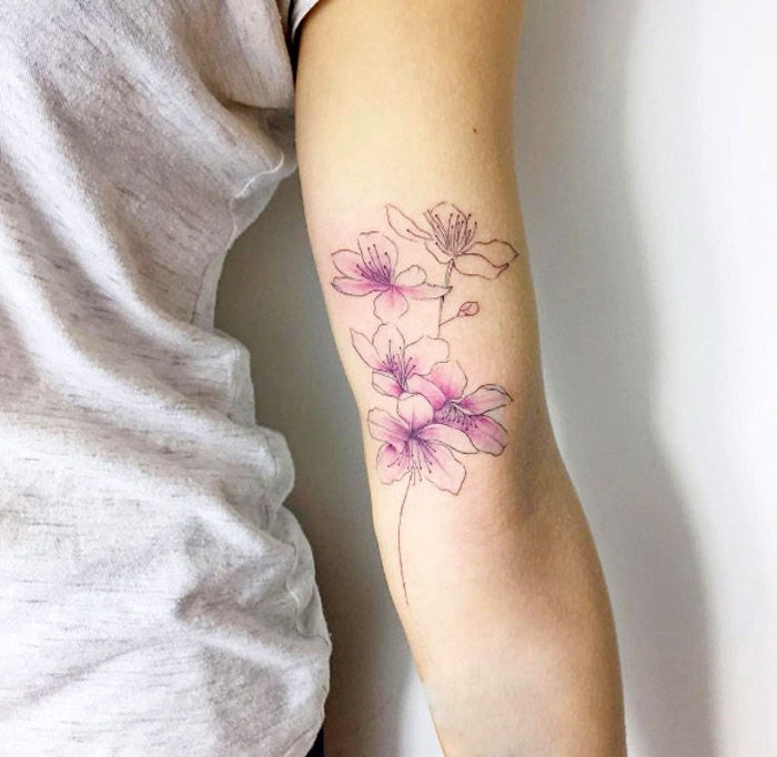 tatoeages met betekenis, gekleurde tatoeage met kersenbloesemmotief, bloemtattoos