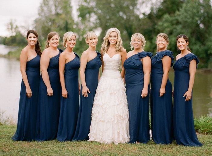 sette damigelle con abiti blu intorno alla sposa tutti con acconciatura diversa acconciatura