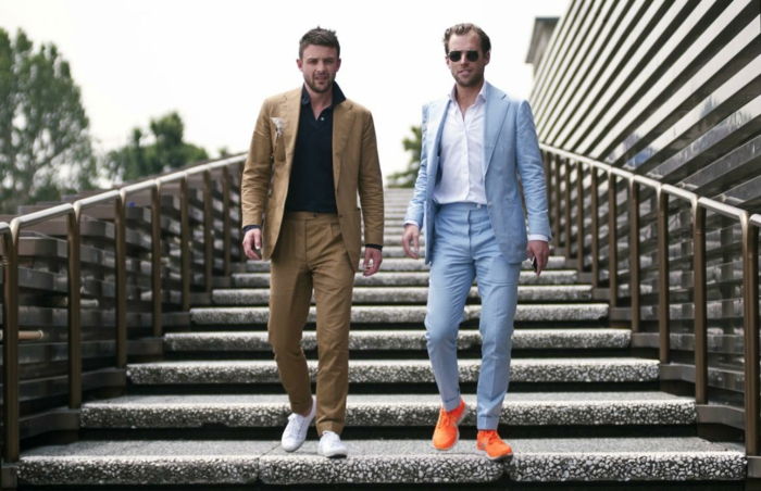 Kollegor två män affärspartners går nerför trappan som bär sneakers och kostym