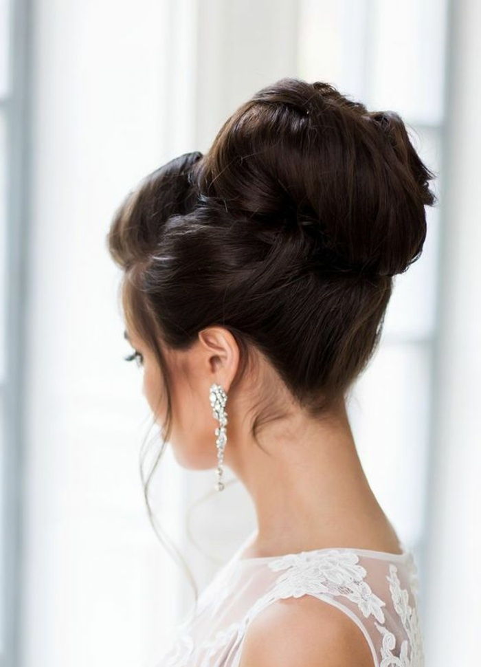 Kvinna med långa silverörhängen och en underbar bröllops frisyr