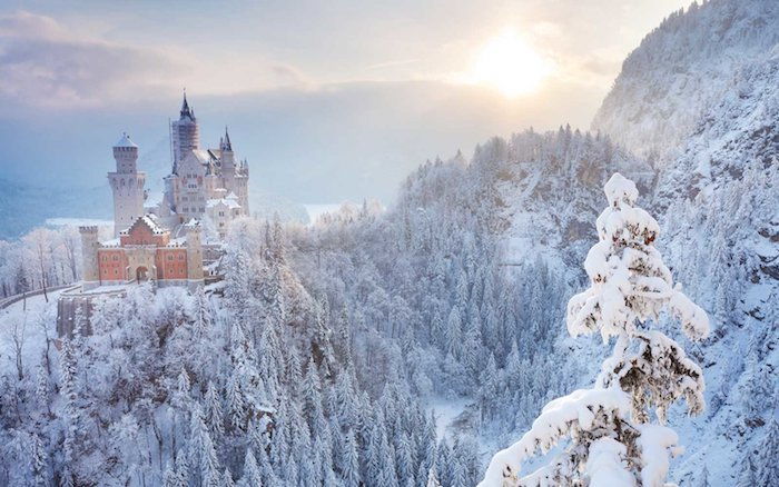 immagini romantiche invernali - un castello con torri nel tramonto - foresta con alberi bianchi e neve