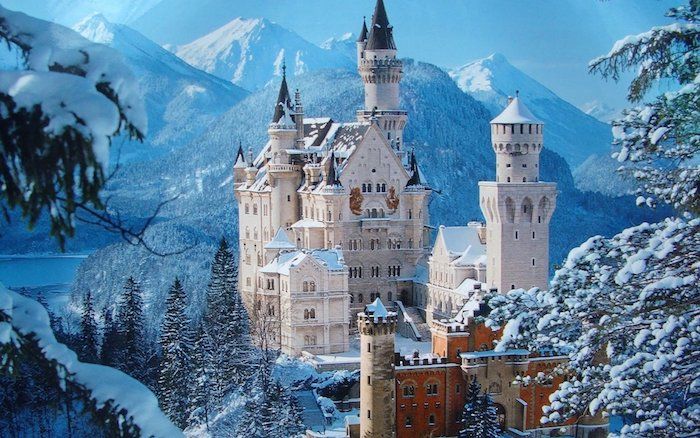un castello bianco con torri e una foresta con alberi - lago e montagne in inverno - belle immagini invernali