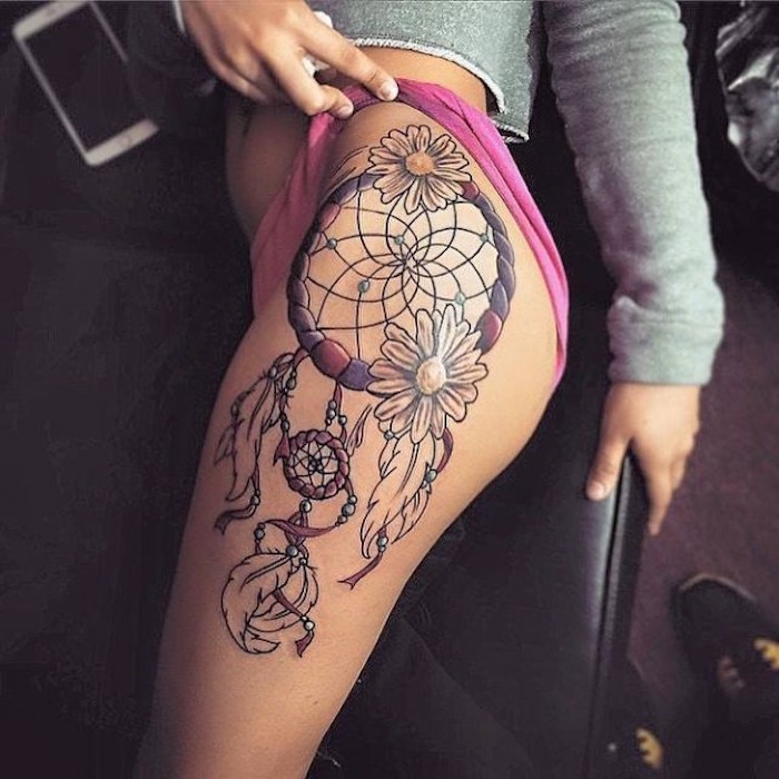 Aruncați o privire la această idee de tatuaj cu un captator de vis cu două flori albe și pene albe lungi - un tatuaj pentru femei