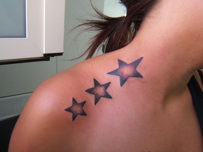 giovane donna con un tatuaggio stella nera con tre grandi stelle