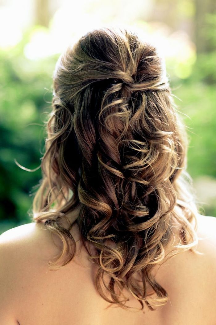 Riccioli e capelli intrecciati sulla cima di semplici acconciature da sposa per creare il tuo