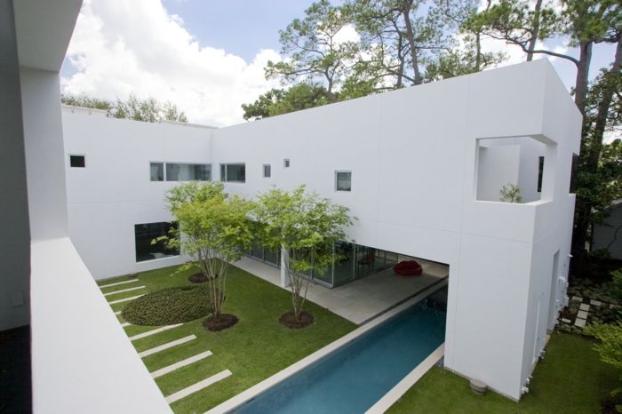minimalistická záhrada vo vnútri nádvoria plného okrasných stromov a kruhu trávy