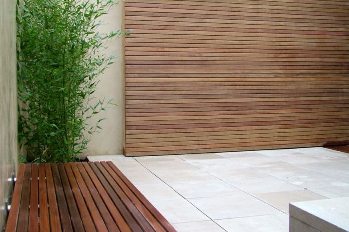 drevená obrazovka, lavička a zelená rastlina, dlažba - minimalistická záhrada
