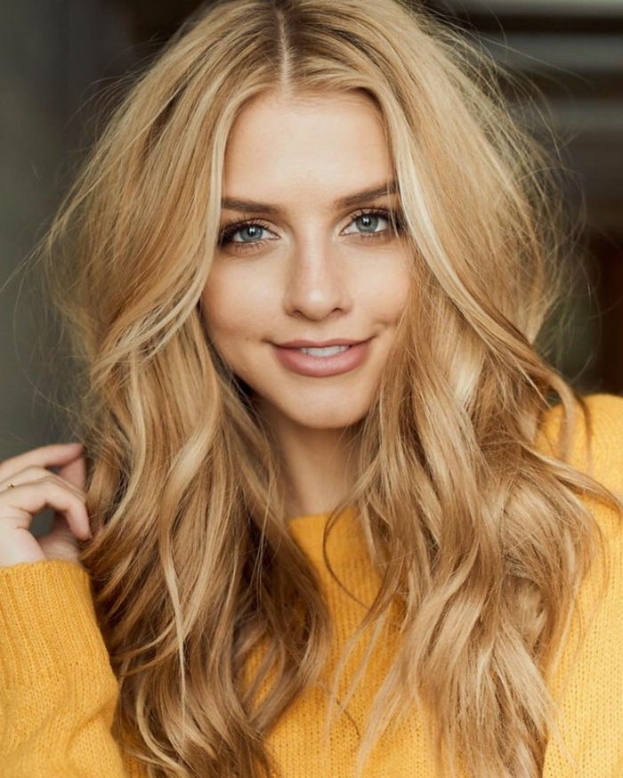 Langt blondt hår med naturlige krøller, dagkrem, delikat leppestift og mascara, gul genser