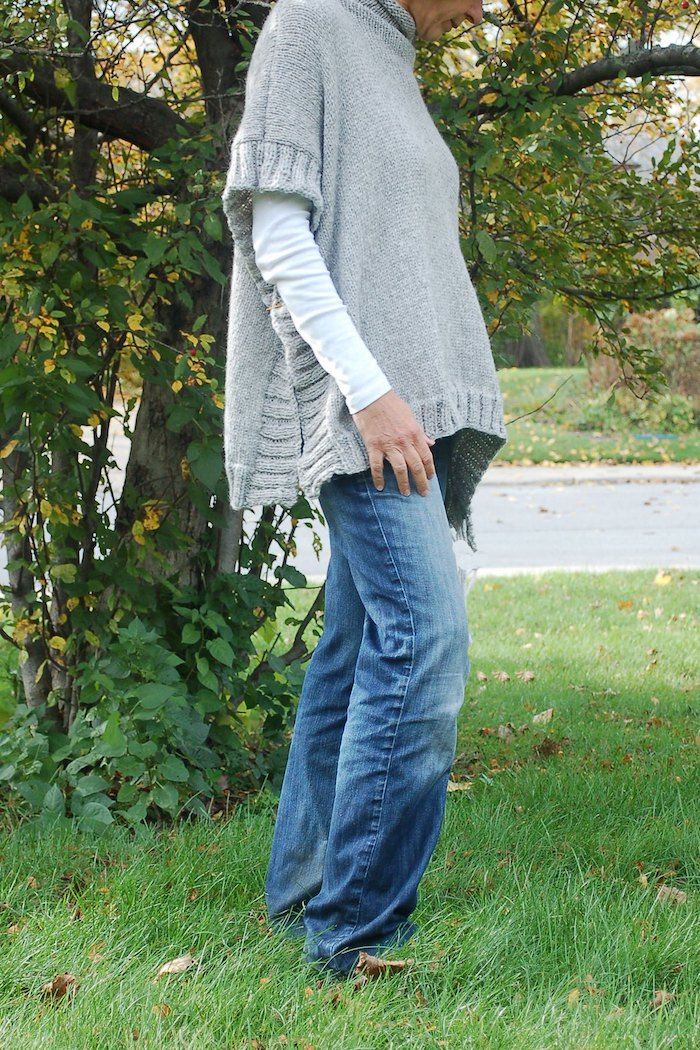 Brei een grijze poncho met patroon op randen in combinatie met jeans
