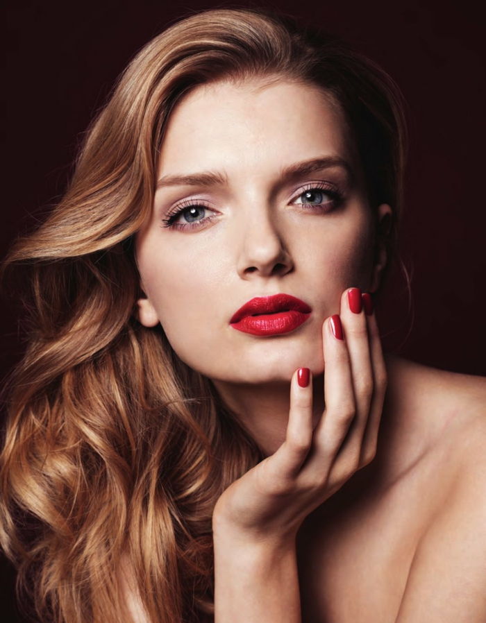 Vakker kvinne med lysebrunt langt hår, lys rødt leppestift og neglelakk, subtil øye sminke