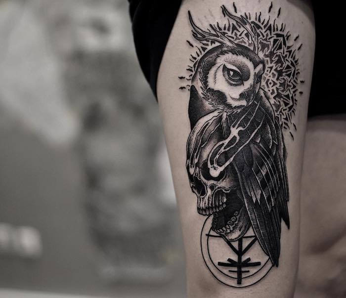 questa è una delle nostre idee per un tatuaggio nero con un gufo nero e un teschio in mano
