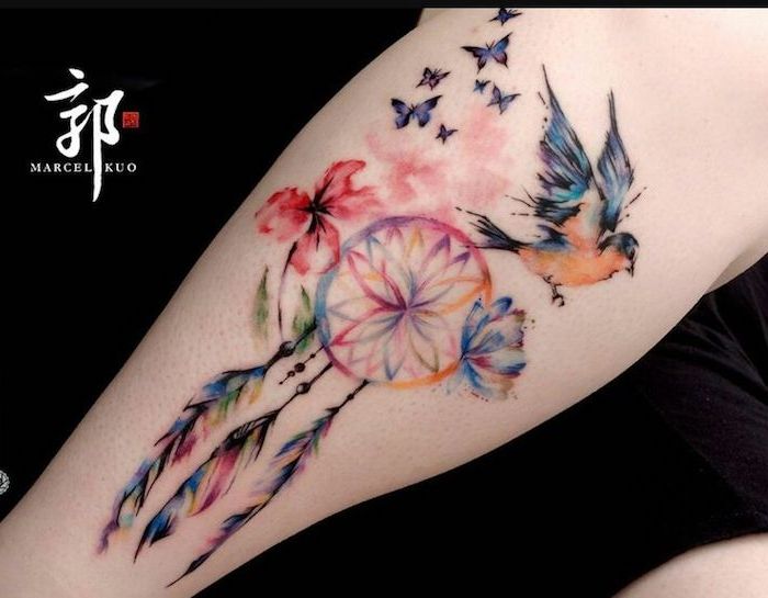 Acum veți găsi o idee pentru un tatuaj colorat cu acuarelă colorată cu fluturi purpurii, cuțit de vis, pene colorate, o pasăre mică și două flori