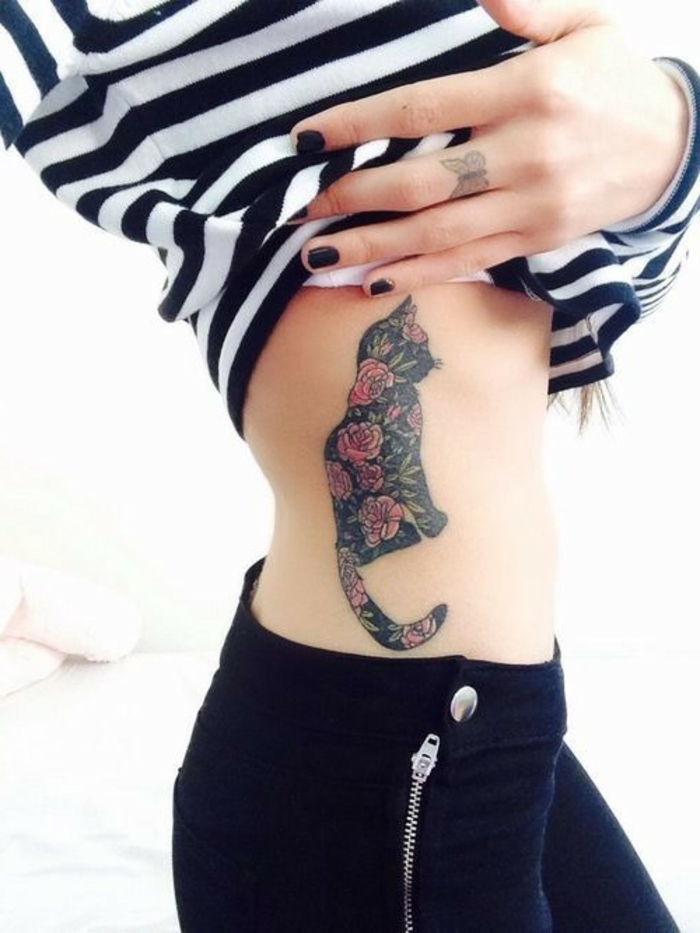 tutaj jest pomysł na tatuaż dla kobiety - tutaj jest tatuaż z czarnym kotem z czerwonymi różami, ręka z tatuażem motyla i czarnym lakierem do paznokci