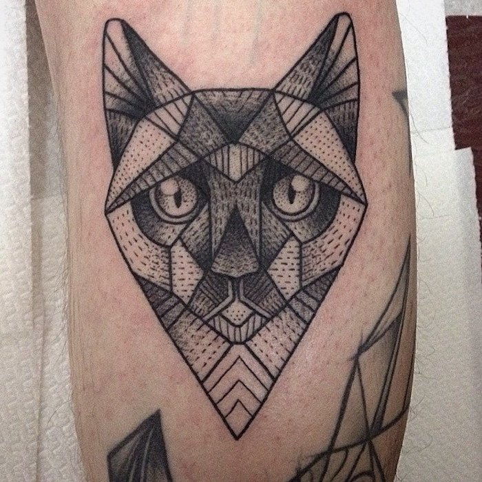Pomysł na czarny tatuaż z kotem o dużych oczach - tatuaż na nodze