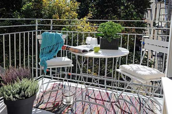fin terrasse med hvite stoler og et rundbord