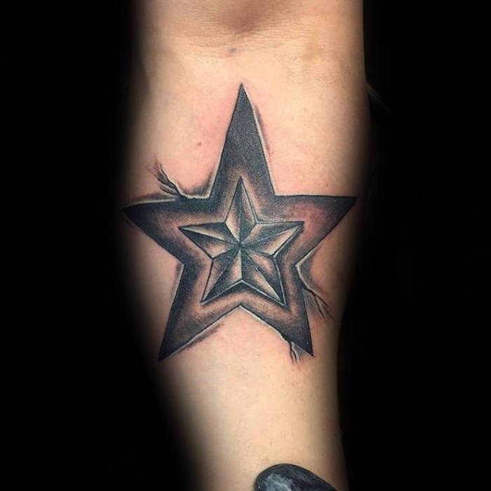 Mano con un tatuaggio nero con una piccola stella e una grande stella nera