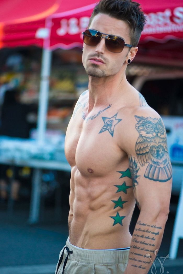 giovane uomo con gli occhiali - un uomo con un tatuaggio stella con stelle verdi e un grande tatuaggio con gufo