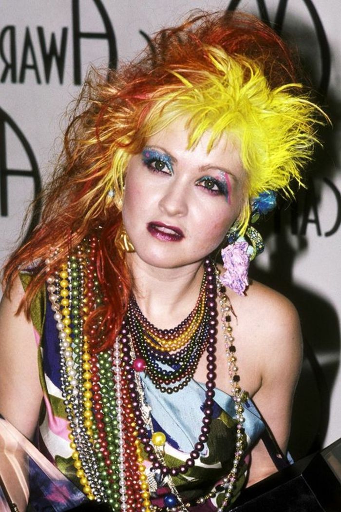 Olhar dos anos 80 - cabelo amarelo, cabelo laranja, muitos colares coloridos, maquiagem neon, top sem alças
