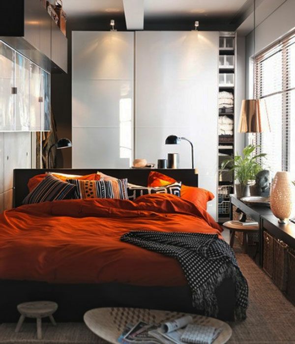 małą przestrzeń ustawione łóżko-z-pomarańczowo-pościelą