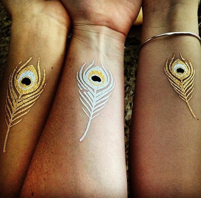 idéias de tatuagem pena de prata ou dourada nas mãos representam sinal para idéias de amizade