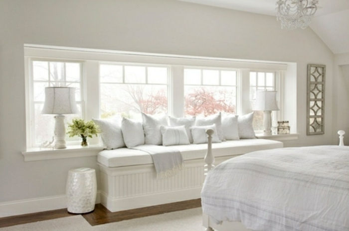 hvitt soverom sitter på vinduskarpene og puter