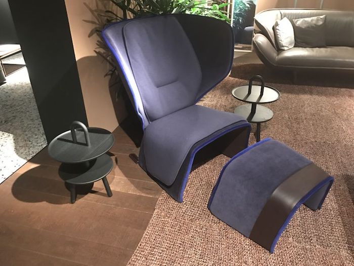 beige designet stue med lilla vinge stol med avføring, speil i hjørnet, overgang til andre rom