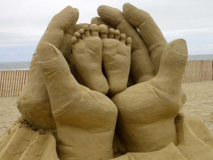 Scultura moderna dai piedi-in-the-hands-of-padre dei bambini di sabbia