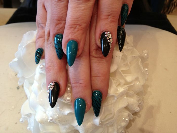 spets naglar idéer dekorationer spik design med stenar på svart och mörkgrön nagelplatta