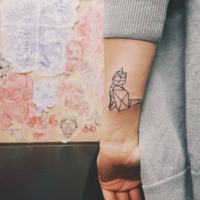 dłoń z małym czarnym tatuażem - pomysł na tatuaż dla kobiet