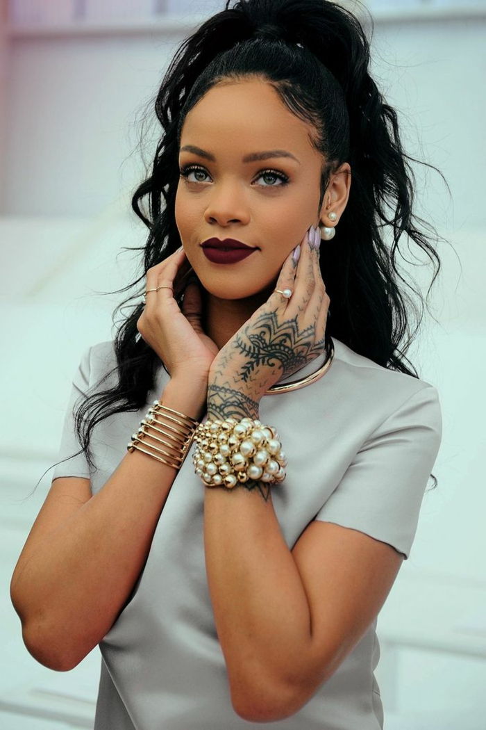 söt look av Rihanna med två armband med pärlor, sprött svart hår med updo frisyr - bästa frisyrer