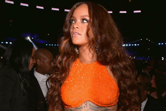 vackra krullar i brun färg med röda höjdpunkter, orange blus - Rihanna frisyr