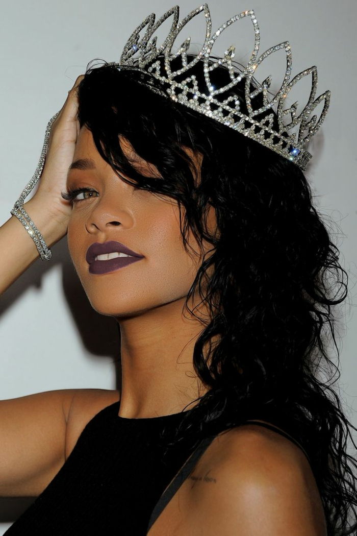 czarne włosy z lokami, duża srebrna korona, czarna szminka - fryzura Rihanna